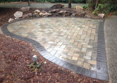 Custom patio design with rounded edges and mulch in landscape adjacent.